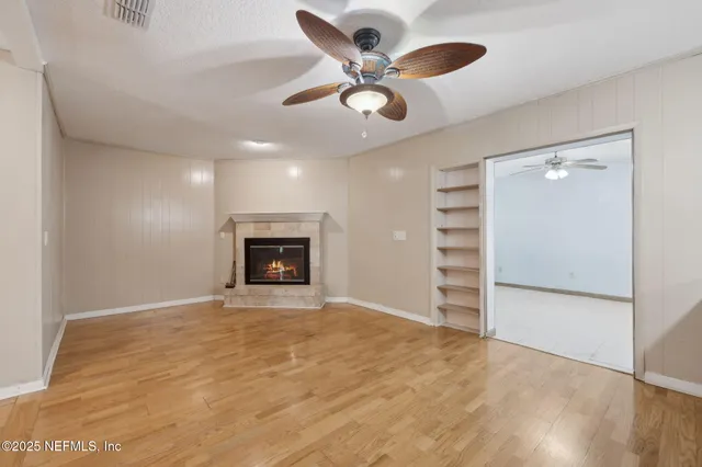 a view of an empty room with a fireplace and a window