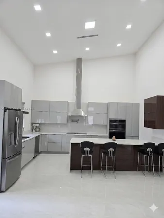 a kitchen with refrigerator and chairs