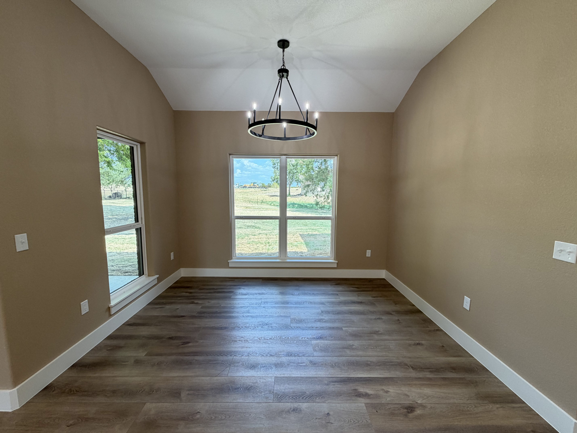 33 Wilderness Road North Calera, OK 74730 - Photo 15 of 39 Vaulted ceiling with a black finish chandelier, wood-finish flooring, and white trim