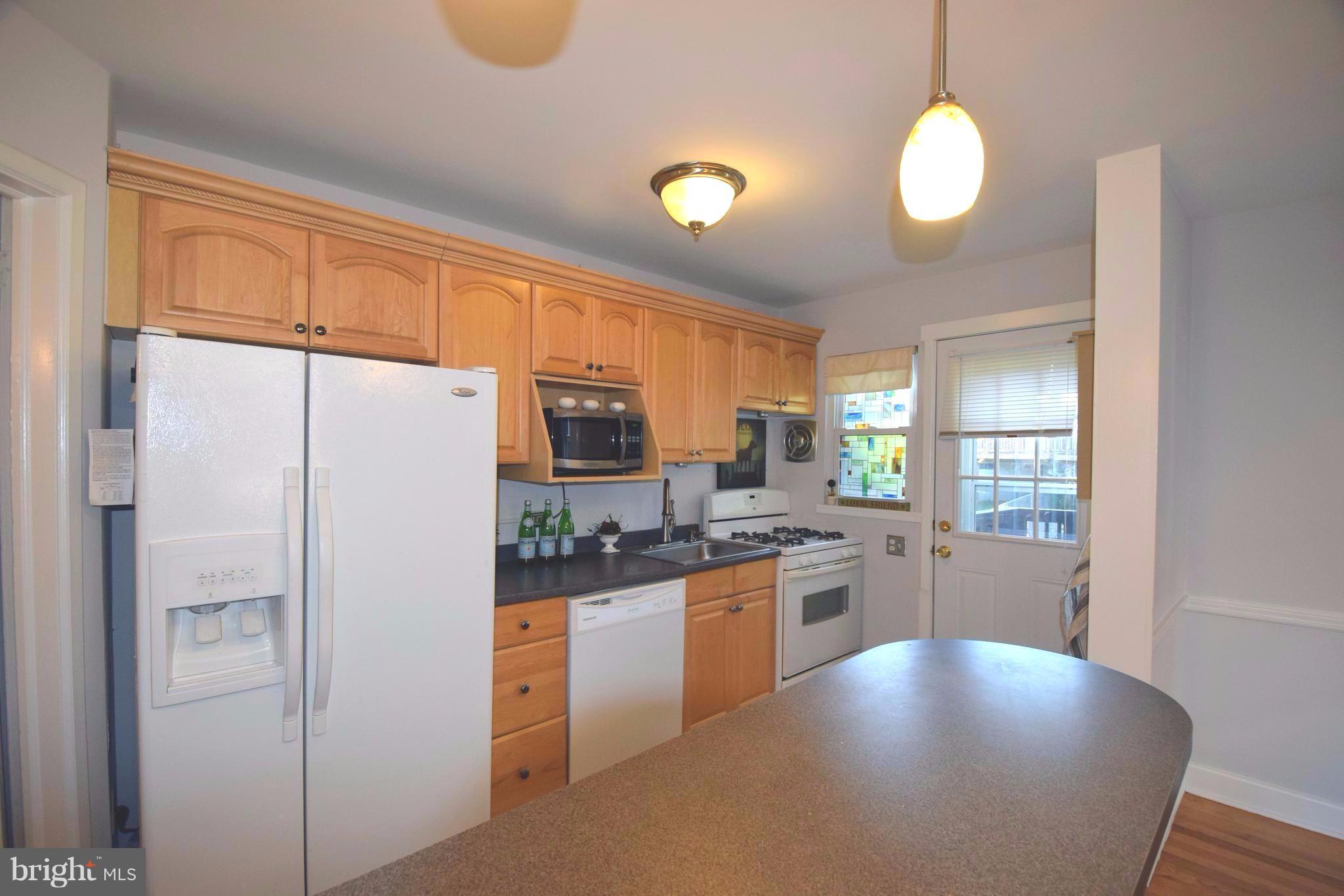 8536 Water Oak Road Baltimore, MD 21234 - Photo 8 of 27 a kitchen with stainless steel appliances granite countertop a refrigerator a stove and a sink with wooden floor
