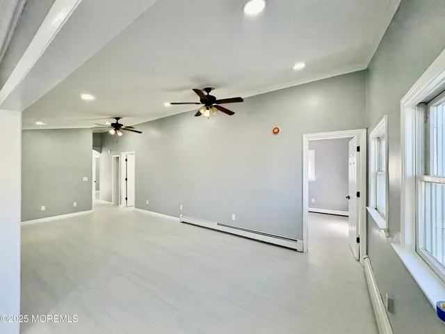 a view of a room with a ceiling fan and window
