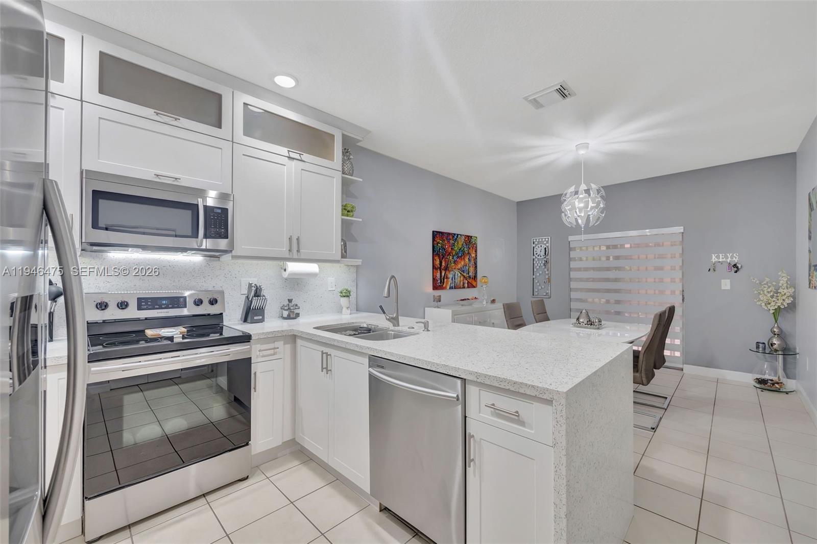 11227 Southwest 230th Terrace, Unit 11227 Miami, FL 33170 - Photo 12 of 37 a kitchen with a stove sink and cabinets