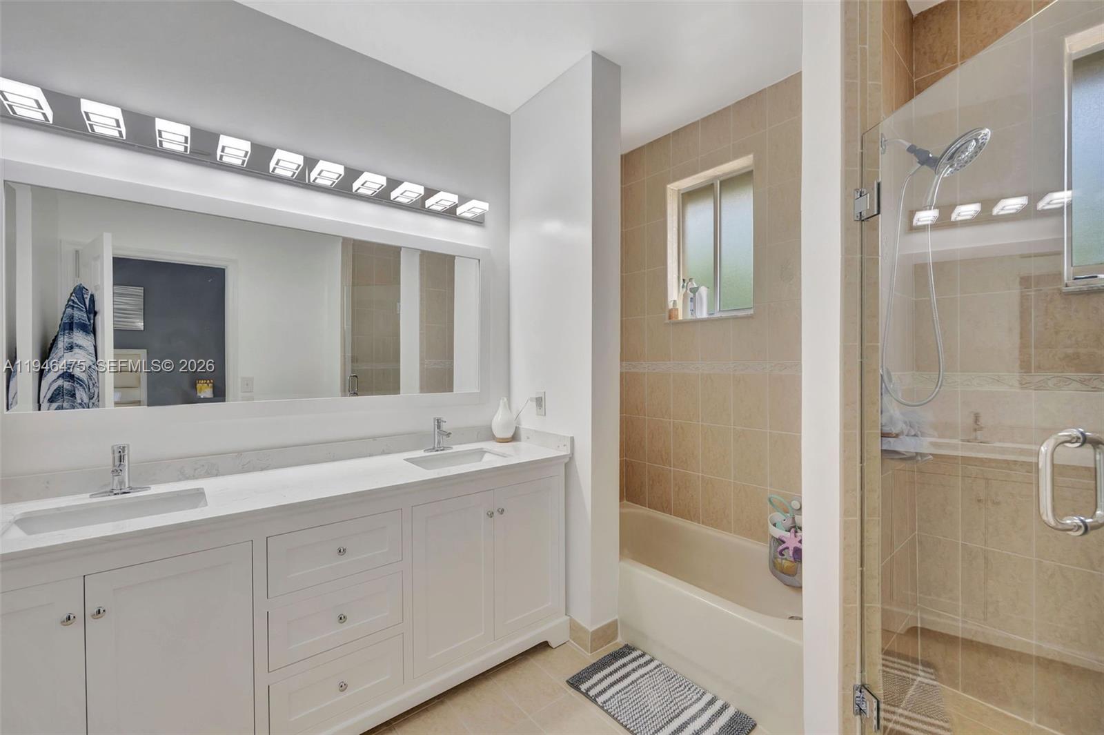 11227 Southwest 230th Terrace, Unit 11227 Miami, FL 33170 - Photo 19 of 37 a bathroom with a tub a sink and mirror