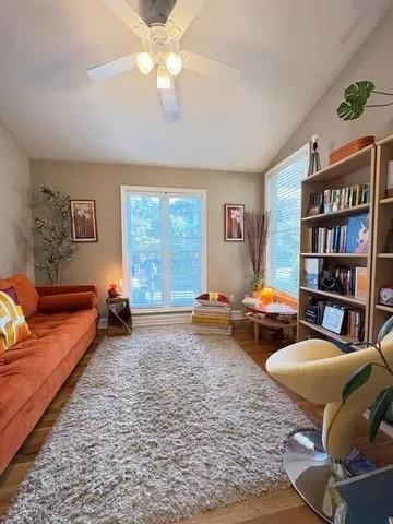 a living room with furniture and a book shelf