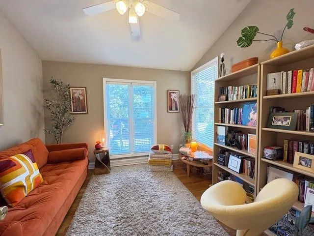 a living room with furniture a bookshelf and a potted plant