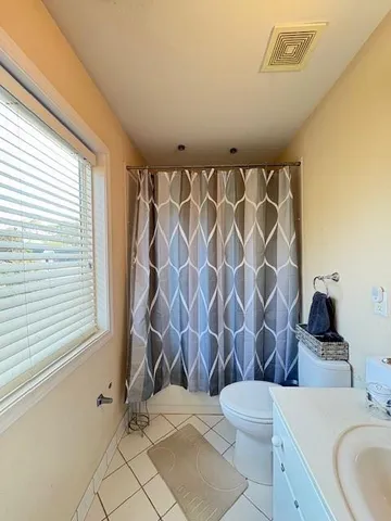 a bathroom with a sink a toilet and shower curtain