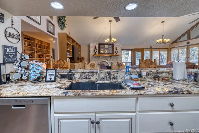 a kitchen with stainless steel appliances kitchen island granite countertop a stove and a sink