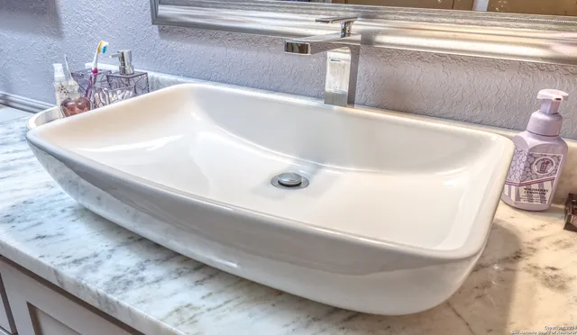 a bathroom with a granite countertop toilet sink and mirror