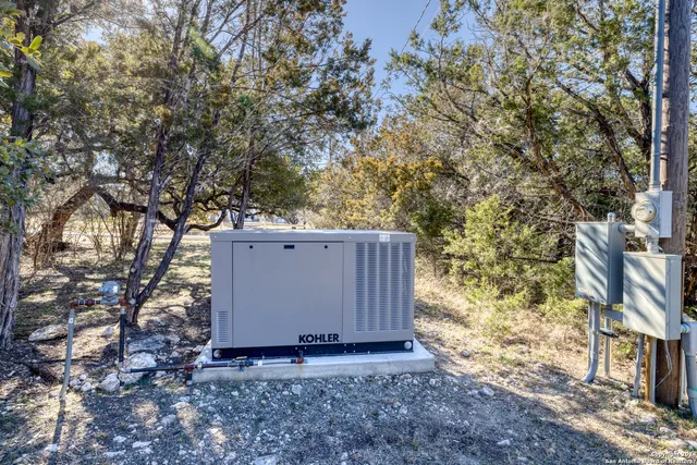 a view of a backyard with large trees and wooden fence