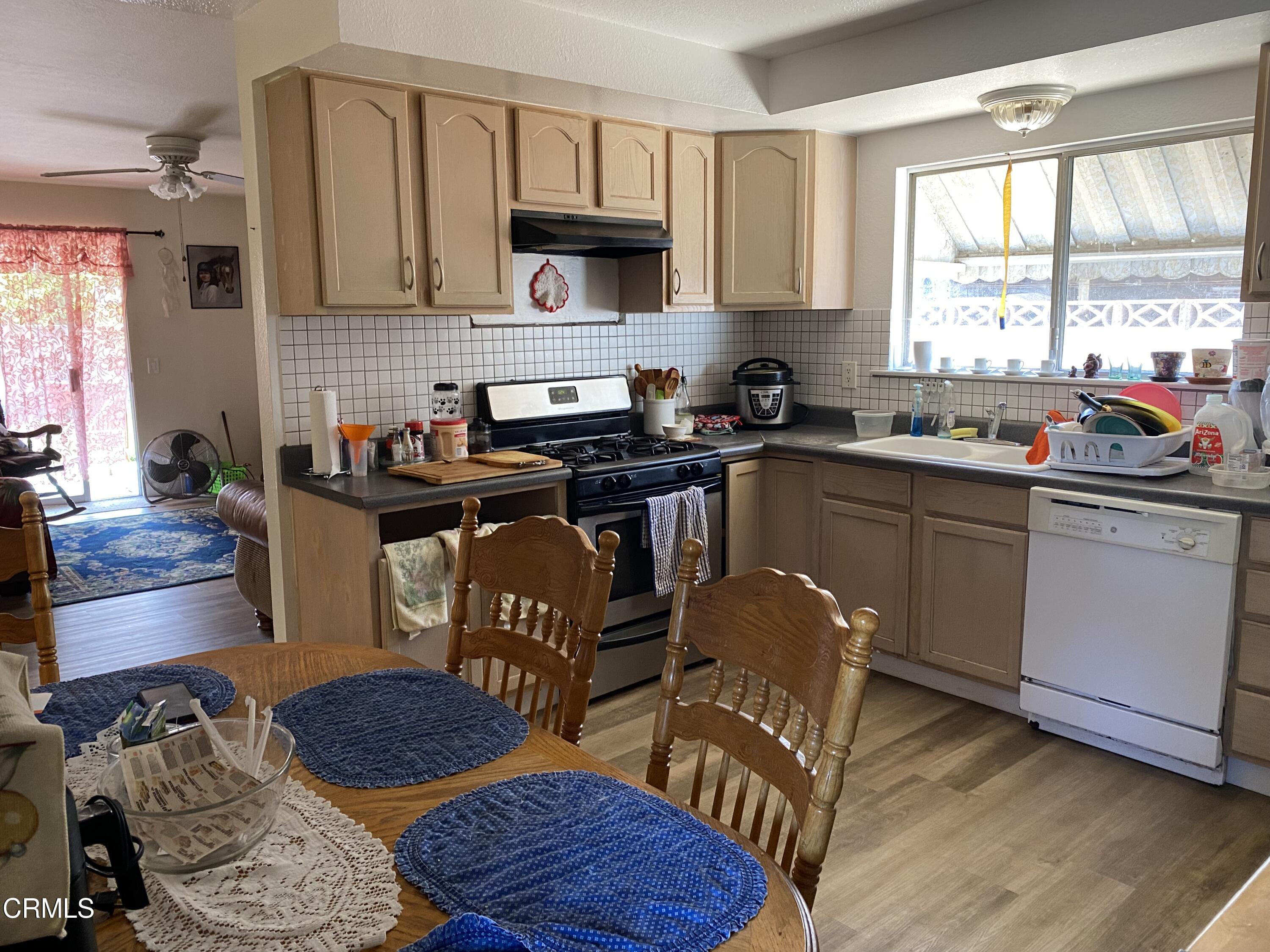1200 Bluebell Street Oxnard, CA 93036 - Photo 4 of 6 a kitchen with stainless steel appliances granite countertop a sink a stove a dining table and chairs