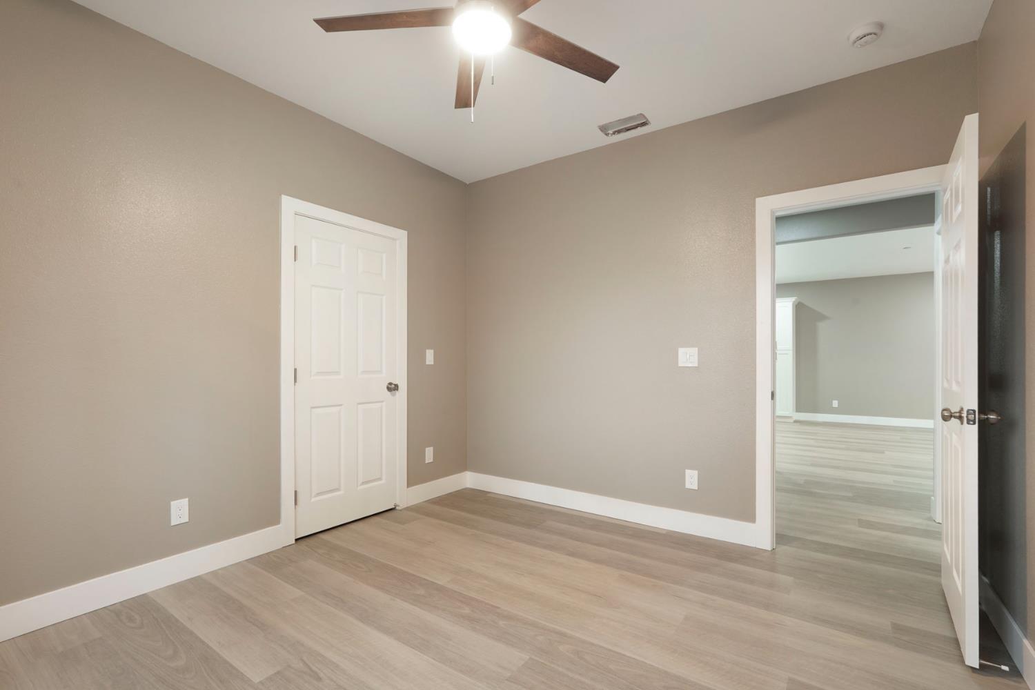 9421 Carter Court Stockton, CA 95209 - Photo 15 of 31 an empty room with wooden floor chandelier fan and windows