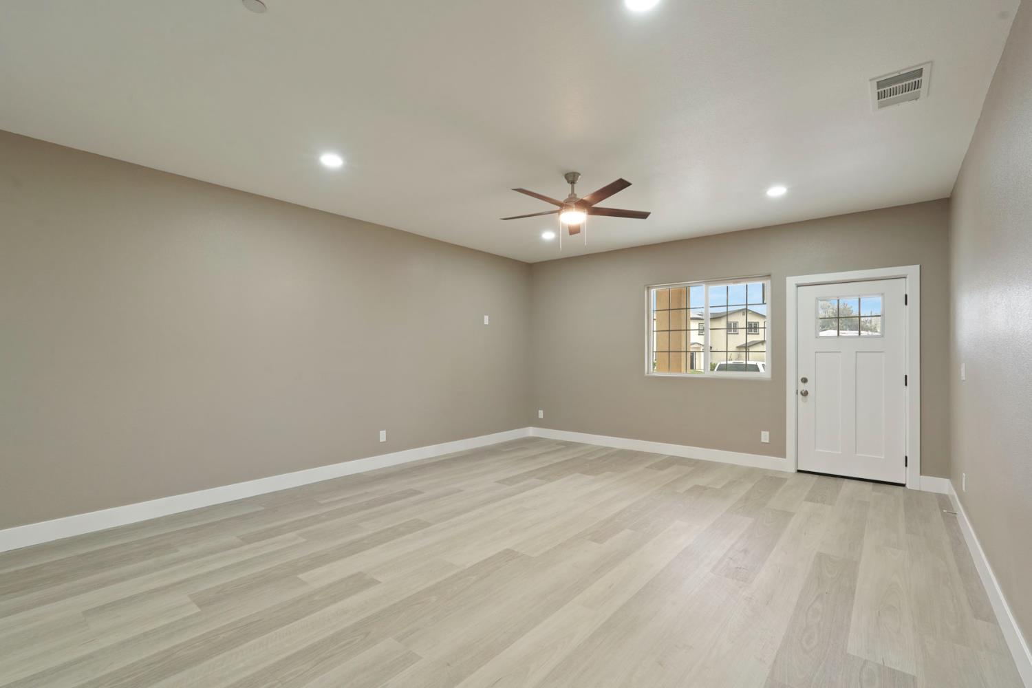 9421 Carter Court Stockton, CA 95209 - Photo 9 of 31 an empty room with windows and chandelier fan