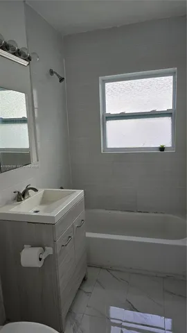 a bathroom with a sink toilet vanity and window