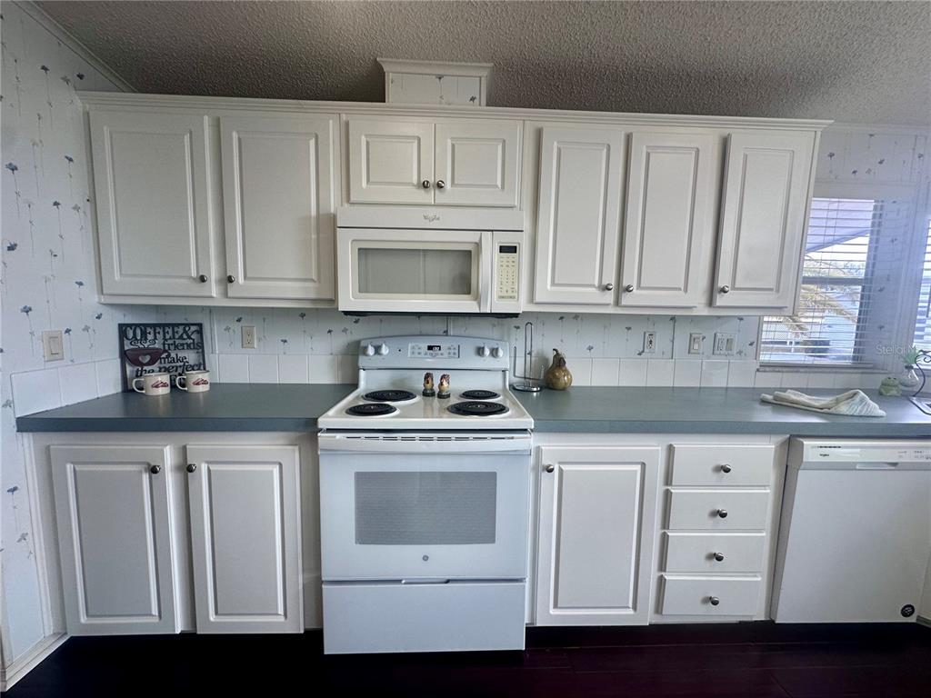 1100 South Belcher Road, Unit 406 Largo, FL 33771 - Photo 8 of 46 a kitchen with white cabinets and white appliances