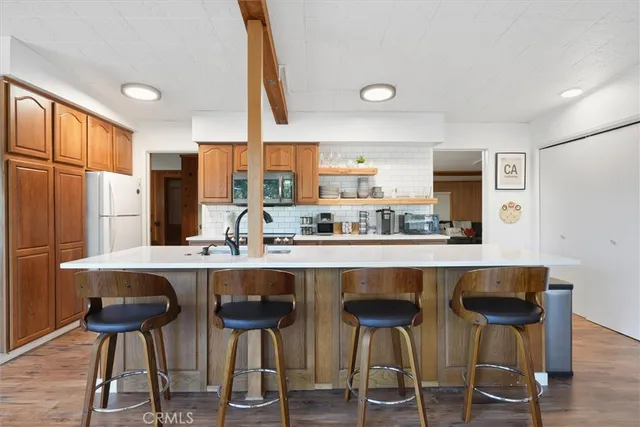 a kitchen with a table chairs refrigerator and cabinets