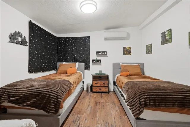 a bedroom with bed and wooden floor