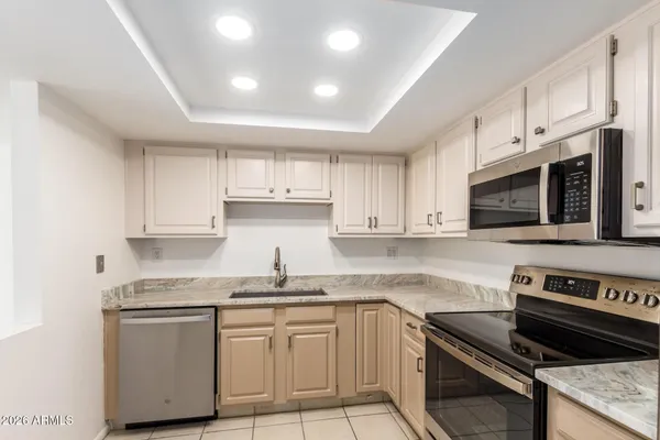 a kitchen with stainless steel appliances granite countertop a stove a sink and a microwave