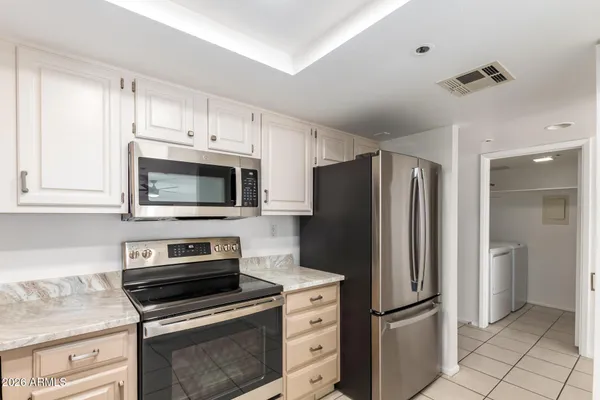 a kitchen with refrigerator a microwave and cabinets