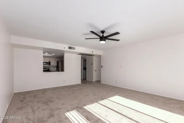a view of a big room with wooden floor a ceiling fan and window