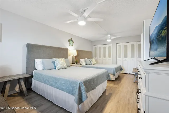 a large bedroom with a bed and a flat screen tv