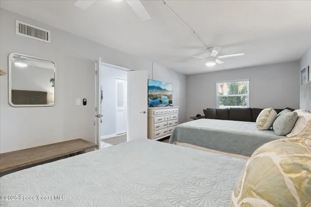 a bedroom with a large bed and a chandelier