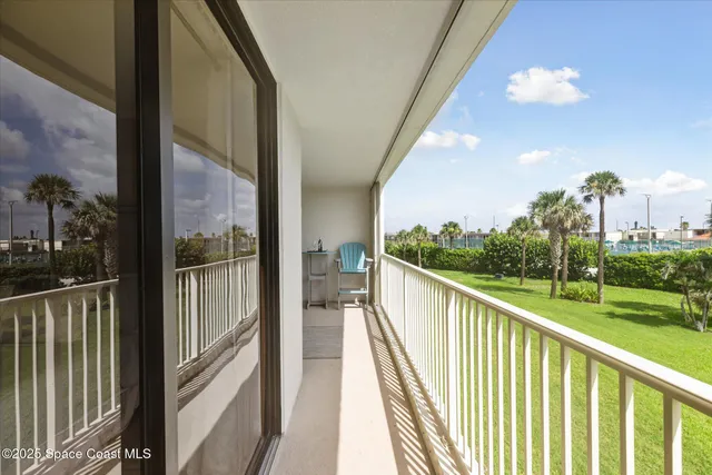 a view of a balcony with a yard