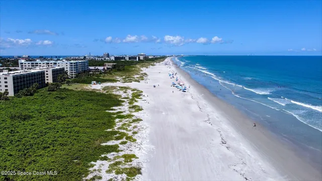 a view of a lake with beach and city