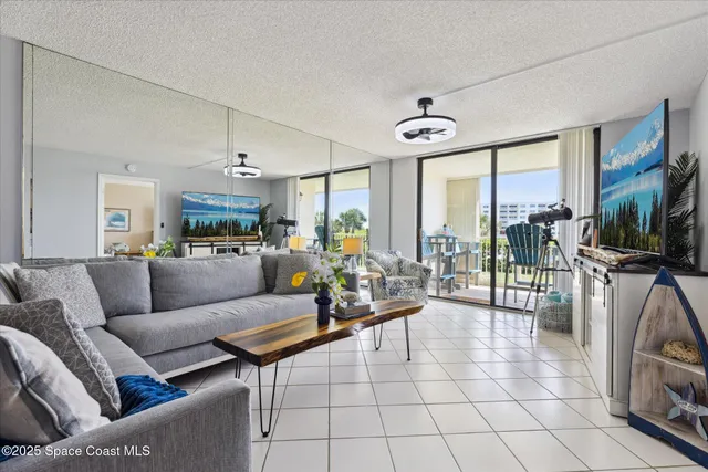 a living room with furniture a flat screen tv and a large window