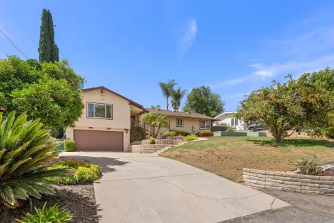 a front view of a house with a yard and trees