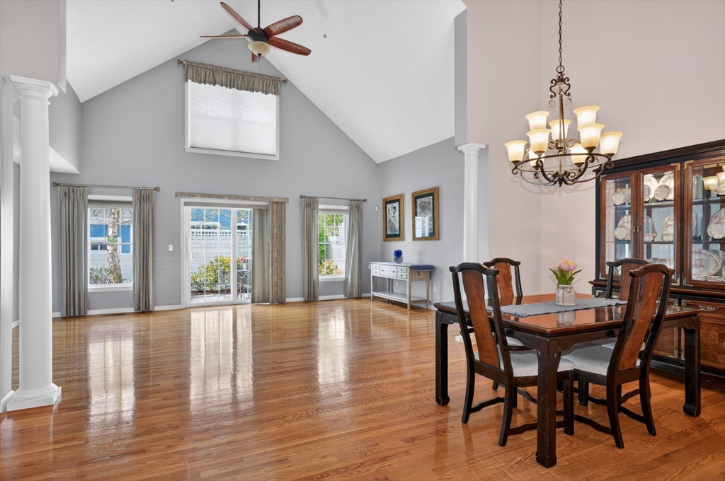 15 Hastings Road, Unit 15 Hudson, MA 01749 - Photo 18 of 40 a dining room with wooden floor a chandelier a wooden table and chairs
