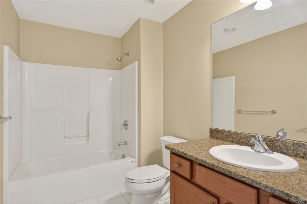 15 Hastings Road, Unit 15 Hudson, MA 01749 - Photo 37 of 40 a bathroom with a granite countertop sink toilet and shower