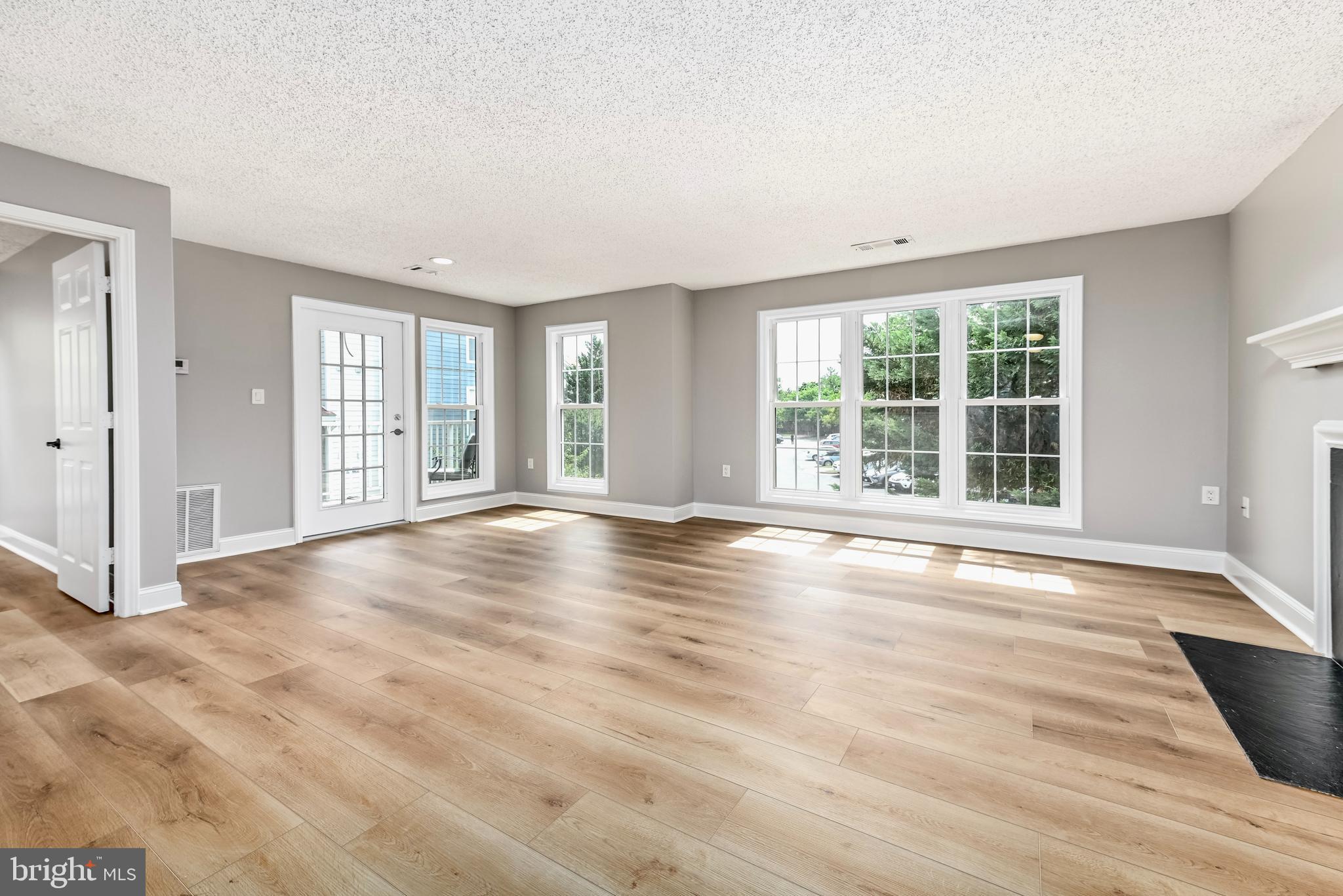 20991 Timber Ridge Terrace, Unit 204 Ashburn, VA 20147 - Photo 3 of 27 Living Room with Fireplace and 3 Large Windows