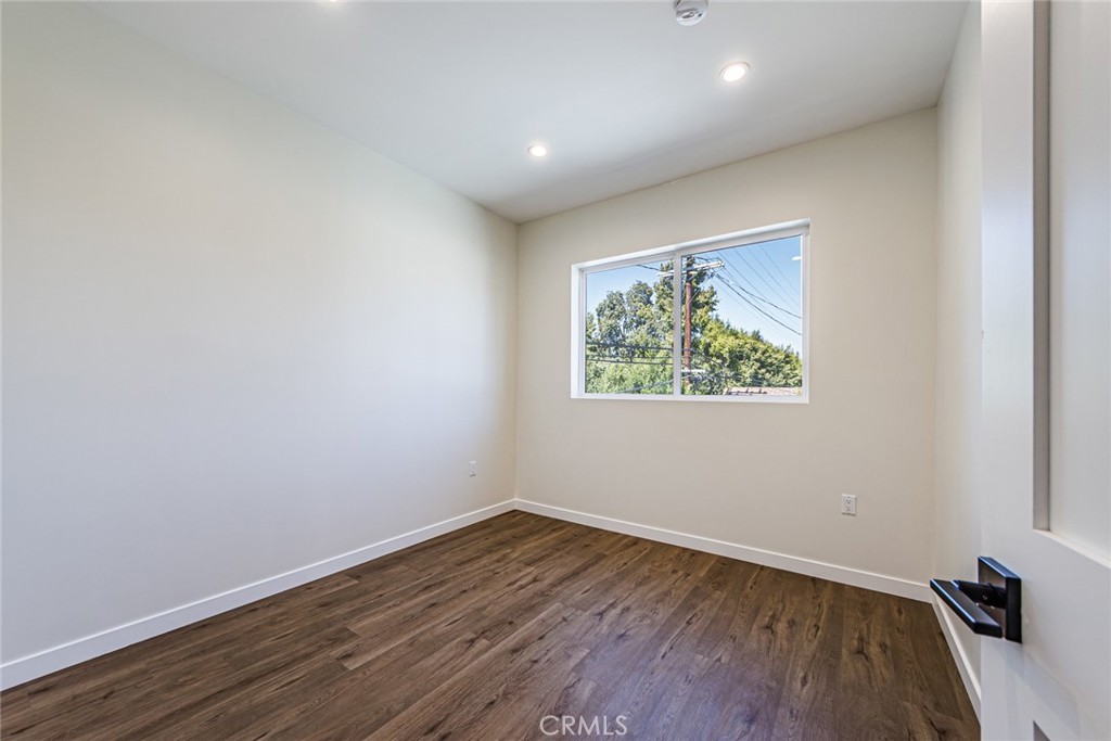 1859 1/2 South Crenshaw Boulevard Los Angeles, CA 90019 - Photo 13 of 29 a view of empty room with wooden floor and fan