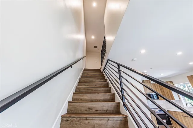 a view of a hallway with wooden floor and staircase