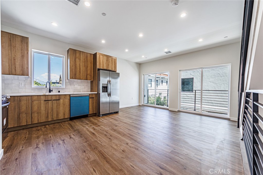 1859 1/2 South Crenshaw Boulevard Los Angeles, CA 90019 - Photo 6 of 29 a kitchen with stainless steel appliances a sink and a wooden floor