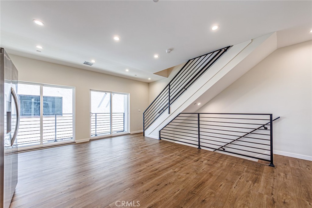 1859 1/2 South Crenshaw Boulevard Los Angeles, CA 90019 - Photo 10 of 29 an empty room with wooden floor and windows
