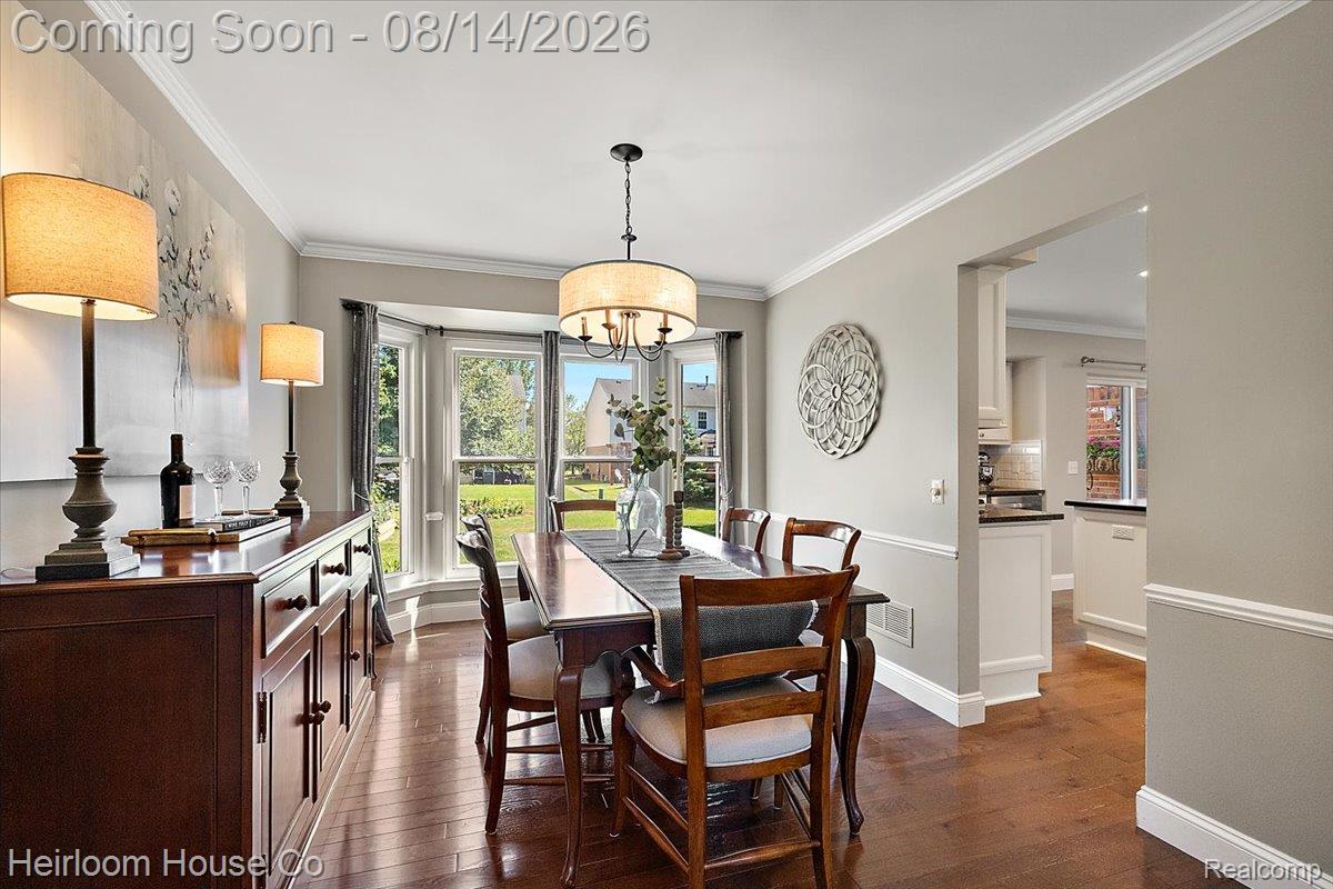 45697 Bryn Mawr Road Canton, MI 48187 - Photo 57 of 75 Dining area featuring wood-finish flooring, a bay window, crown molding, and a chandelier