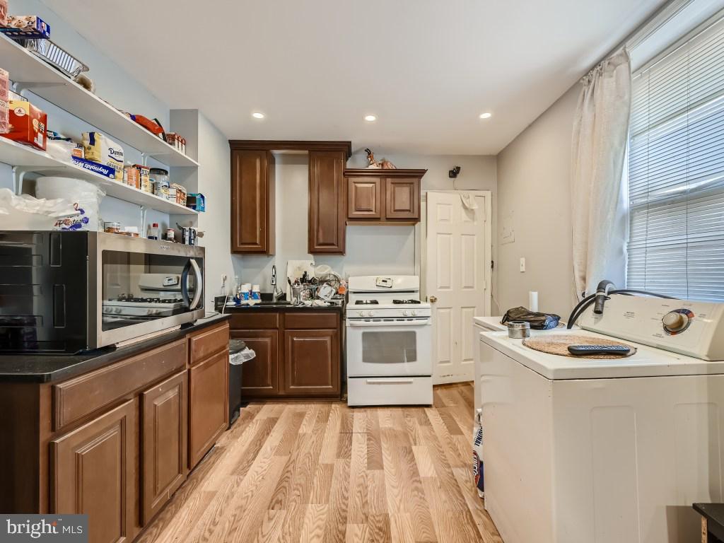 1402 Carroll Street Baltimore, MD 21230 - Photo 20 of 28 a kitchen with stainless steel appliances granite countertop a sink stove and refrigerator