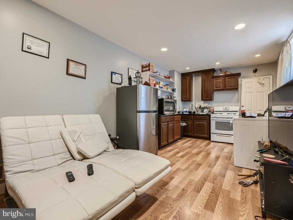 1402 Carroll Street Baltimore, MD 21230 - Photo 24 of 28 a kitchen with stainless steel appliances a refrigerator sink stove microwave and cabinets