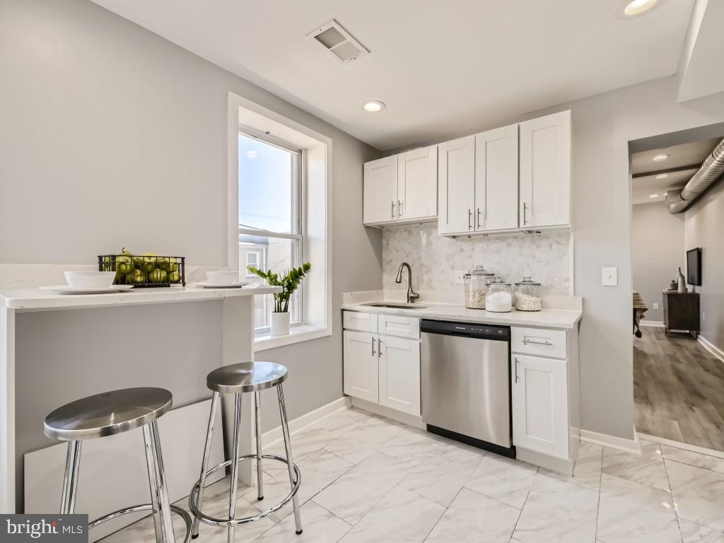 1402 Carroll Street Baltimore, MD 21230 - Photo 6 of 28 a kitchen with a stove cabinets and chairs