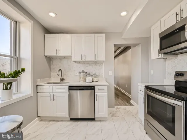 a kitchen with stainless steel appliances a stove sink microwave and cabinets