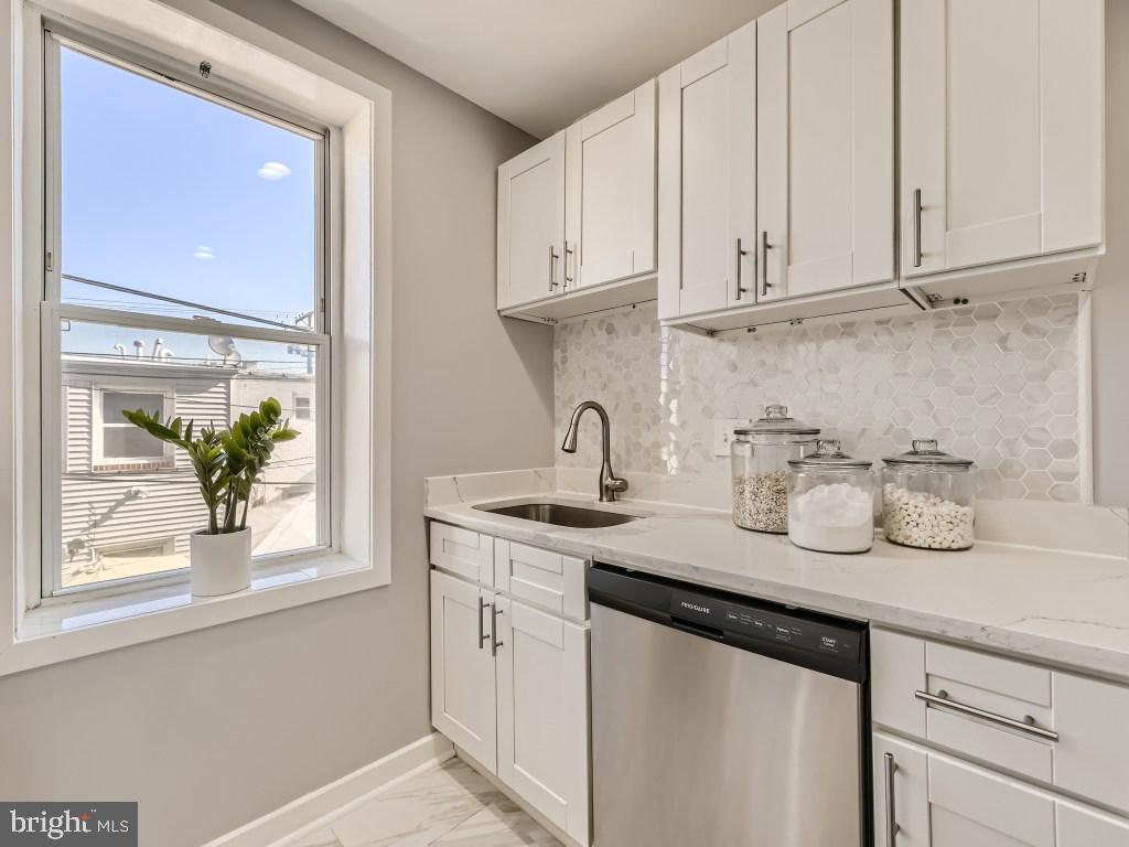 1402 Carroll Street Baltimore, MD 21230 - Photo 8 of 28 a kitchen with stainless steel appliances granite countertop white cabinets and a sink