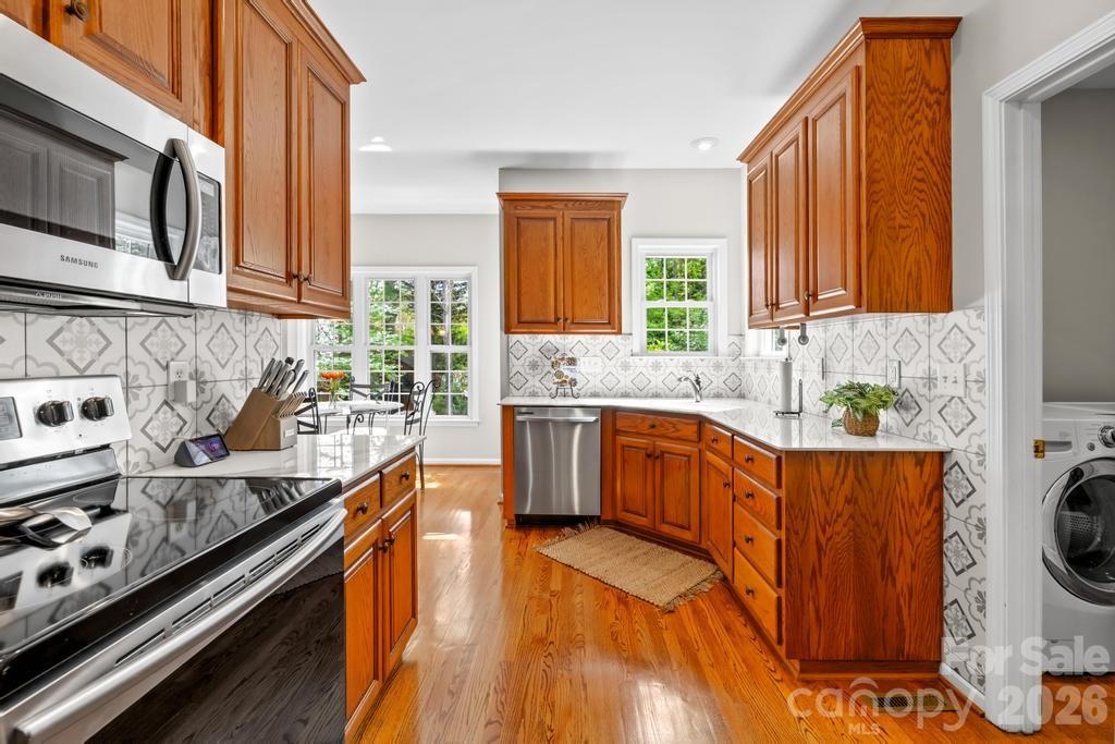 17028 Hampton Trace Road Huntersville, NC 28078 - Photo 13 of 41 a kitchen with stainless steel appliances granite countertop a stove a sink and a microwave