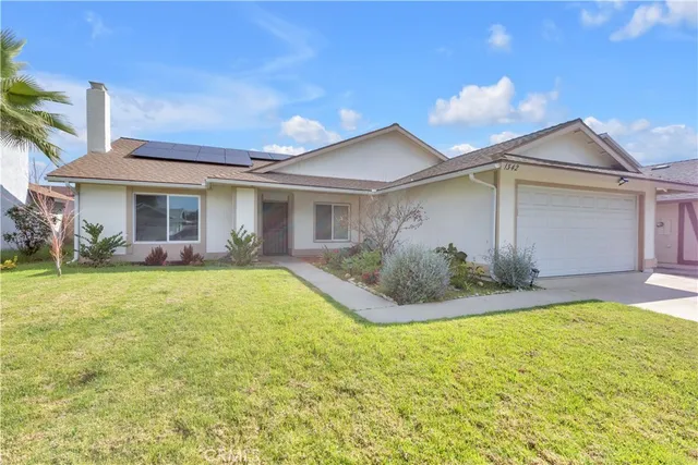 a view of a house with a yard and potted plants