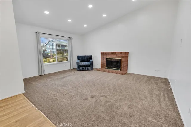 an empty room with windows and fireplace