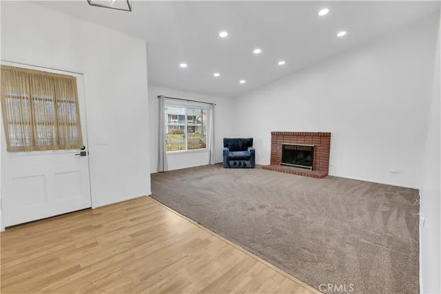 a view of empty room with a fireplace and window