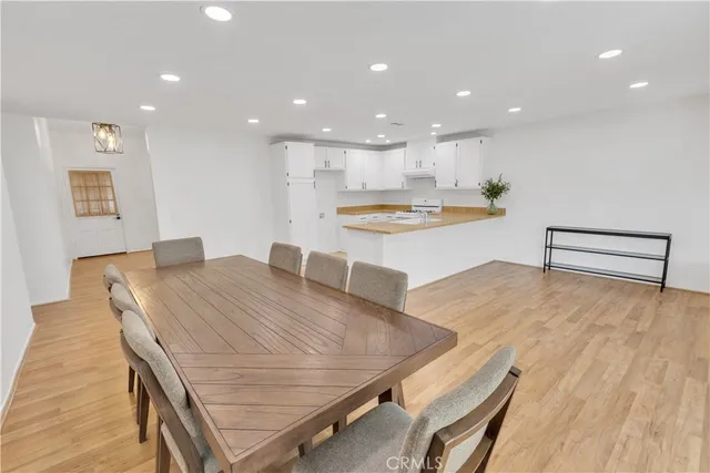 a large kitchen with kitchen island a stove a table and chairs in it