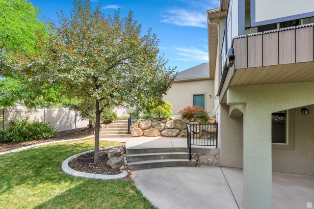 373 East Alexander Drive Elk Ridge, UT 84651 - Photo 51 of 69 Terraced landscaping with concrete steps, wrought iron railing, and stone retaining wall