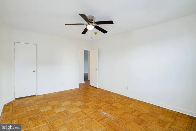 a view of a big room with wooden floor and windows