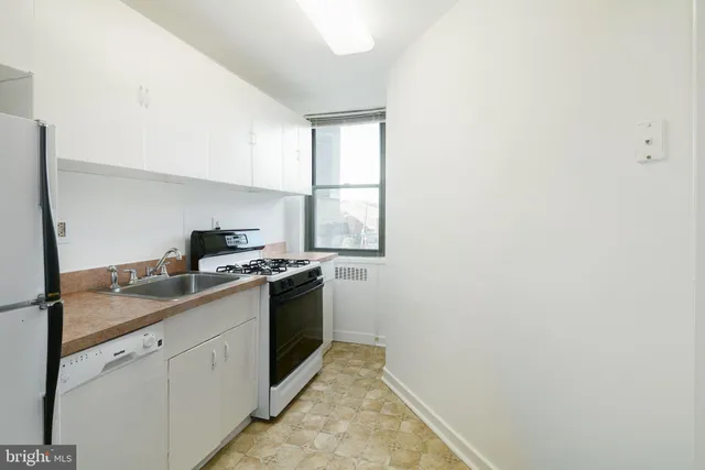 a kitchen with cabinets appliances and a window